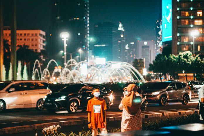 man and woman standing on road during night time