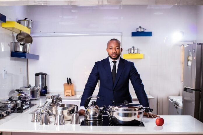 man in black suit standing near stainless steel cooking pot