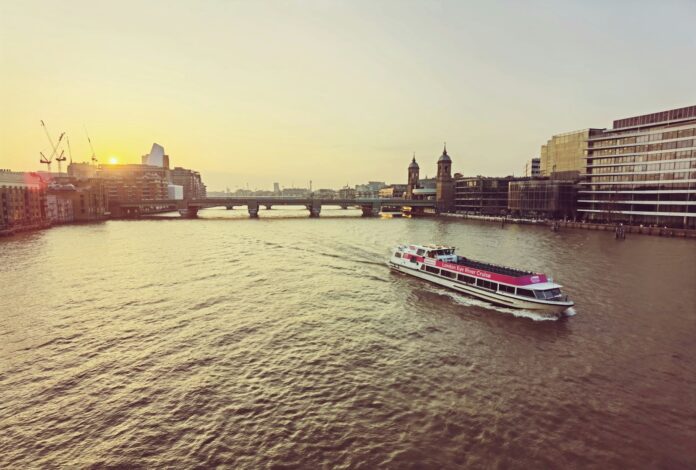 a boat traveling down a river next to tall buildings