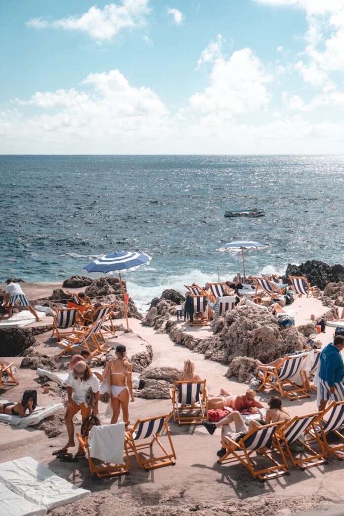 people standing near beach line