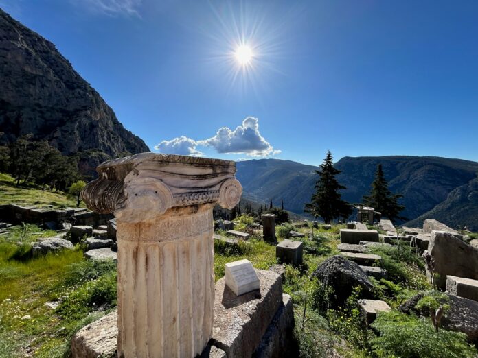 a stone pillar sitting on top of a lush green hillside