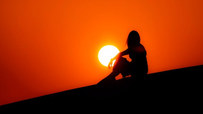 silhouette of woman sitting on ground