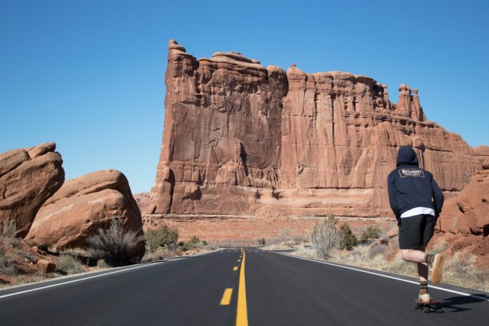 person in blue hoodie skateboarding near ruins